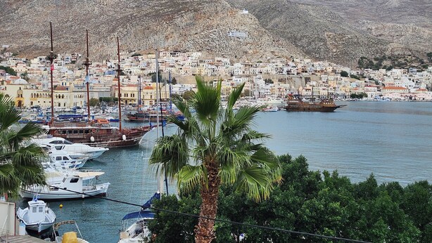 A coastal town with a marina, boats, and a mountainous backdrop. - Archontiko Hotel (Kalymnos)