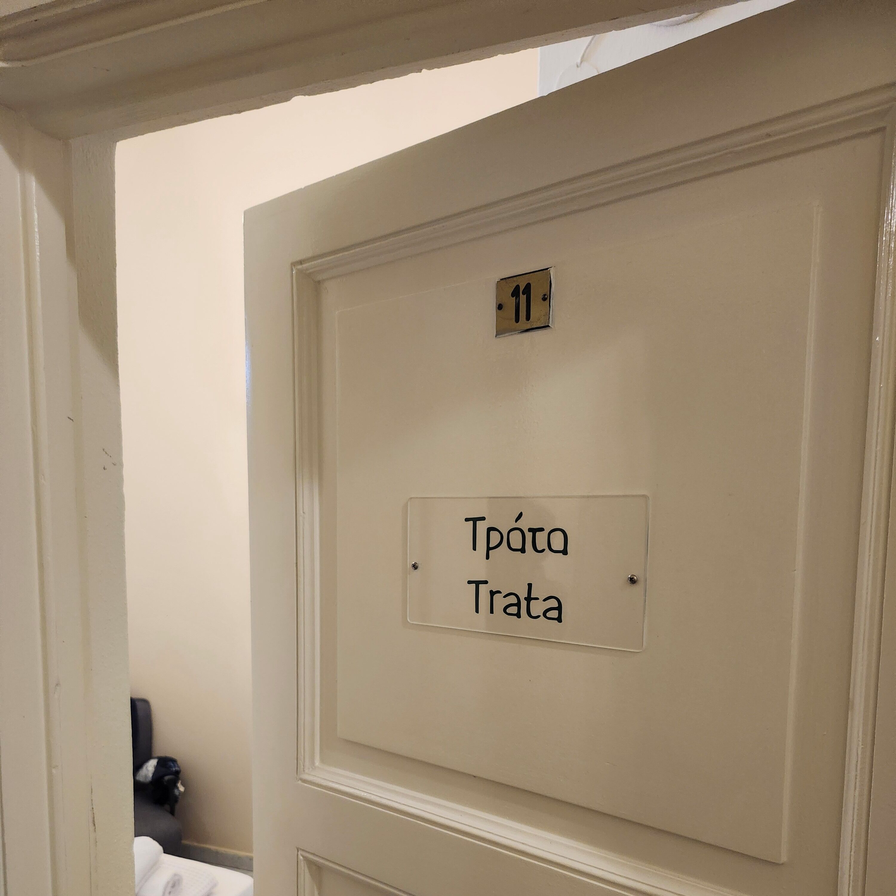 Una puerta con una placa de número '11' y un cartel que dice 'Trata'.