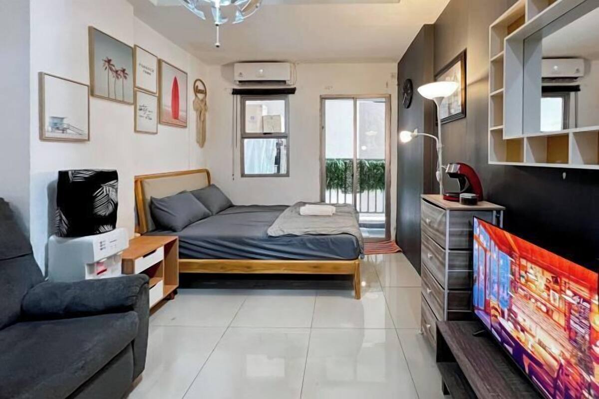 Une chambre moderne équipée d’un lit, d’une télévision, d’un bureau et d’une armoire.