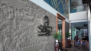 A stone wall with a sign reading "Sage Health & Wellness." - Queensland Manor Condominium Deluxe Suite (Cebu City)