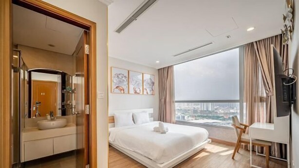 A modern hotel room with a large bed, a desk, a chair, and a view of the city. - Landmark Center Saigon (Ho Chi Minh City)