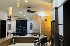 Una cocina moderna con comedor, ventilador de techo y un muro decorativo de madera.