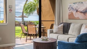 Un salón con vista al océano, un comedor con asientos exteriores y un letrero que dice "NO FUMAR" en la pared.