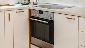 Una cocina equipada con horno empotrado, hervidor y tostadora.