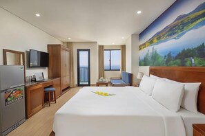 Une chambre d’hôtel avec un lit, un bureau, une télévision et un tableau au mur.