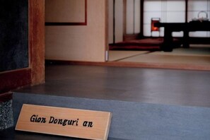 A wooden nameplate with the text 'Gion Donguri an' on a grey floor. - Gion Donguri An (Kyoto)