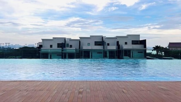 A modern building with a pool in the foreground. - Paragon Residence Johor Bahru (Johor Bahru)