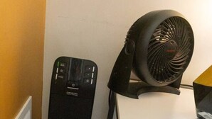 En datorlåda, en fläkt och ett skrivbord med en bärbar dator.