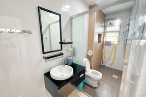 A modern bathroom with a sink, toilet, and shower area.