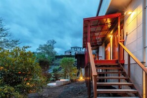 A staircase leading to a building with a red frame, surrounded by vegetation and a clear sky. - VILLA + SECCA (Ito)