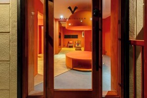Un couloir d’hôtel avec une table ronde et un canapé au fond.