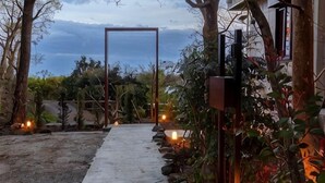 A pathway leading to a structure surrounded by vegetation and a view of the sky. - VILLA + SECCA (Ito)