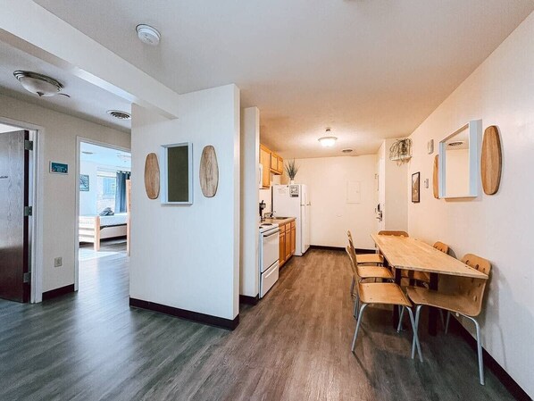 Una cocina moderna con armarios de madera, una mesa de comedor con sillas y una pequeña isla.