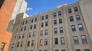 Un immeuble à plusieurs étages, doté d’une façade en briques et de nombreuses fenêtres.