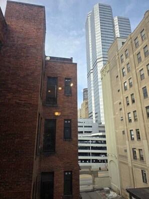 A multi-story building with a brick facade and a modern glass building in the background.