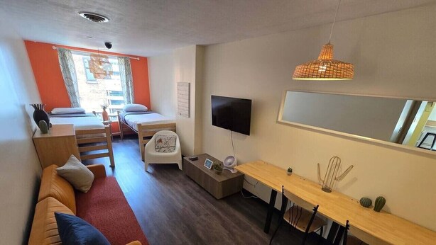 Un salon moderne avec un canapé, une table à manger et un téléviseur.
