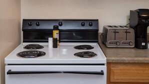 A kitchen with a white stove, a microwave, a toaster, and a coffee maker. - Large Private Downtown Apartment | 2BR + 2BA + 60” (Pittsburgh)
