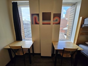 Escritorio, tabla de planchar con plancha, wifi y ropa de cama