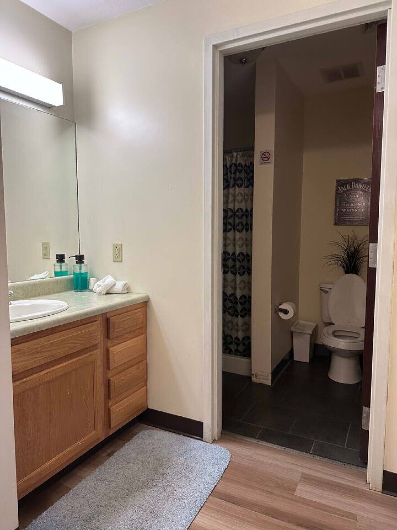 Une salle de bain avec un lavabo, un miroir et des meubles en bois.