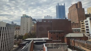 A cityscape with various buildings, including a prominent blue skyscraper and several brick structures. - 2BR 2BA Downtown Apt | Spacious + Walkable (Pittsburgh)