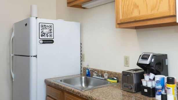 A kitchen with a refrigerator, a coffee maker, and a toaster. - 2 Bedroom Downtown Apartment | Perfect for Groups (Pittsburgh)