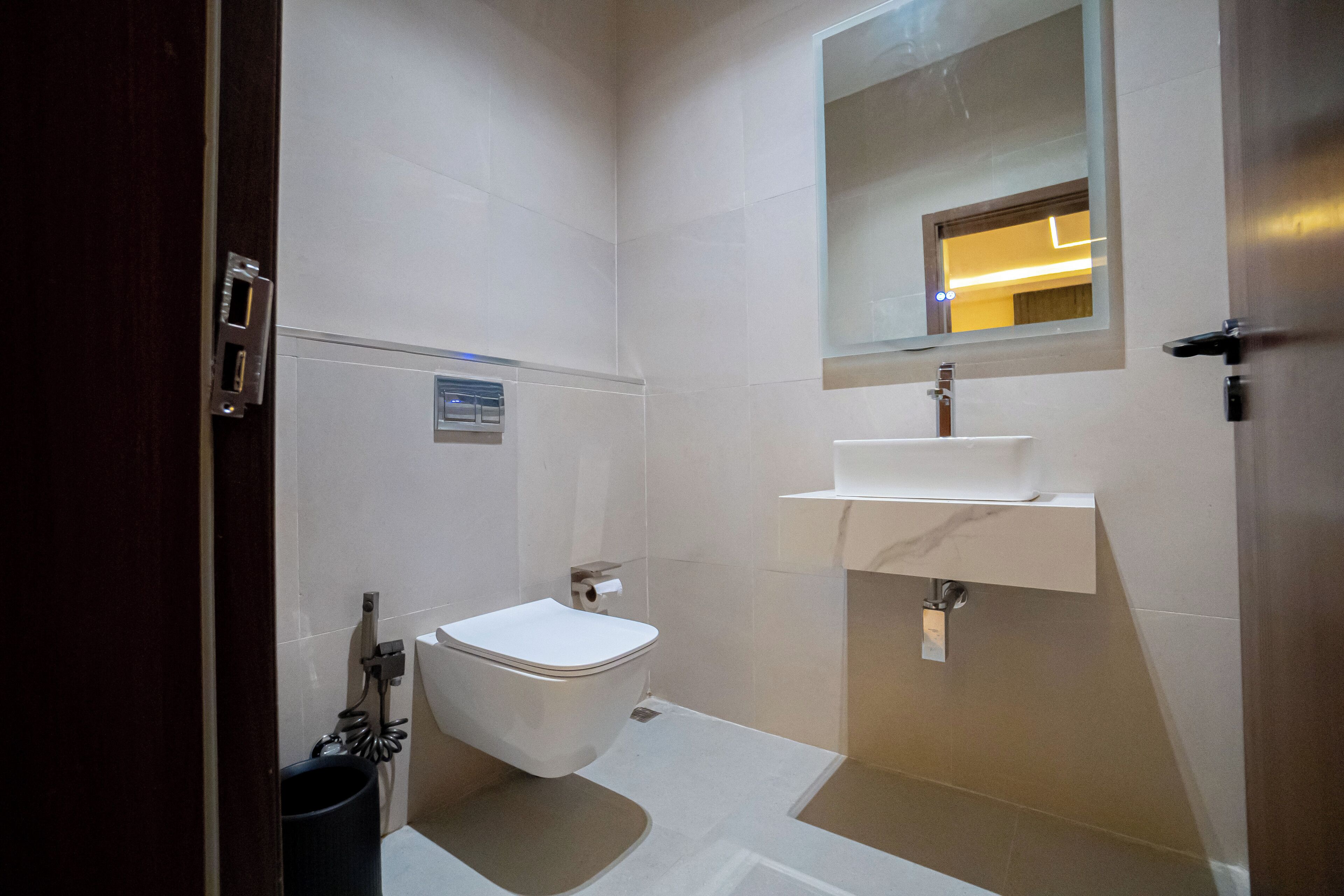 Une salle de bain moderne équipée de toilettes, d’un lavabo et d’un miroir.