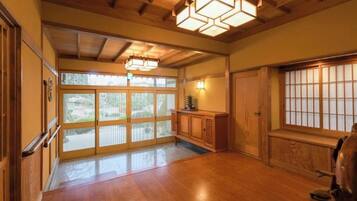 A traditional interior with wooden flooring, sliding doors, and a wooden ceiling with exposed beams.