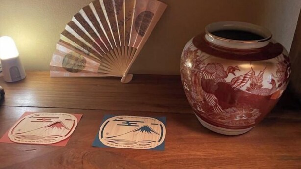 A wooden table with a decorative ceramic vase, a fan, and two wooden plaques. - KazenoRyoan-Fuga (Koshu)