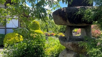 Una característica ornamental de jardín con una estructura de piedra en capas, rodeada de vegetación exuberante y diversas plantas.