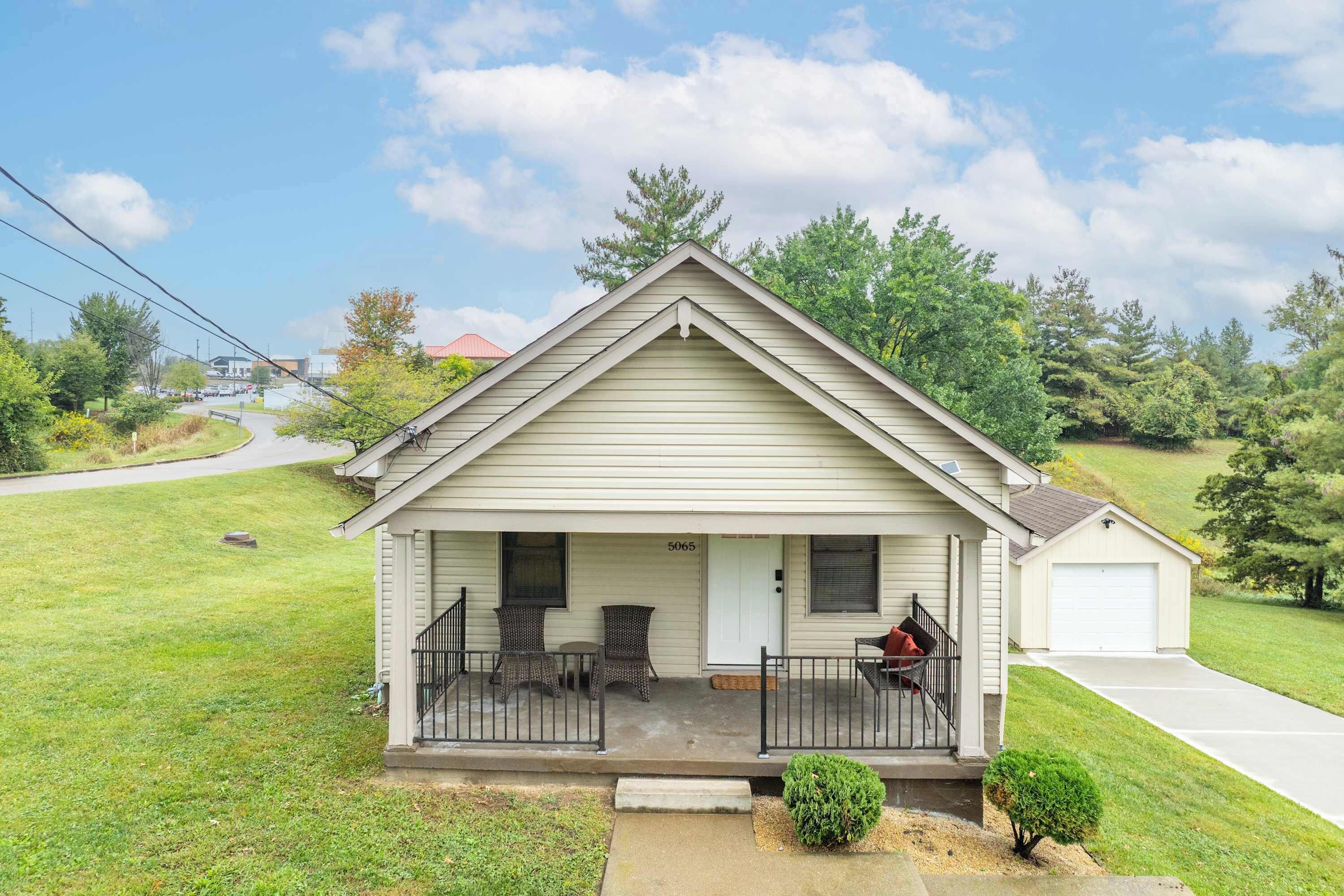 A single-story house with a front porch, a garage, and a small front yard.