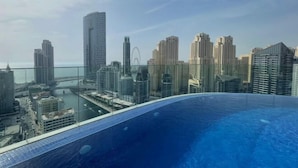 Un edificio alto con vista a un paisaje urbano y una piscina grande.