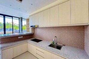 A modern kitchen with a granite countertop, a stainless steel sink, and light-colored cabinets. - Dajan Dukuh Villa (2 Bedroom Villa with Minimum Stay 2 Night) (Bali)
