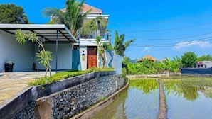 A modern house with a stone retaining wall and a water feature in front. - Dajan Dukuh Villa (2 Bedroom Villa with Minimum Stay 2 Night) (Bali)
