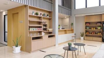 A spacious living area with a high ceiling, a balcony with a railing, and a variety of shelves and furniture.