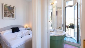 A bedroom with a bed, bedside table, and a painting on the wall. - Rental in Rome Ripa Apartment (Rome)