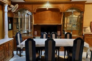 A dining area with a long table, chairs, and a fireplace. - Bigg Villa at Walking Street (Pattaya)