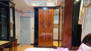 Ein Schlafzimmer mit Bett, Kleiderschrank und Spiegel.
