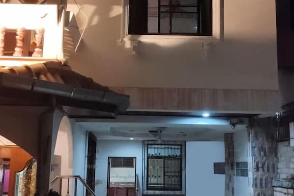 Una habitación con ventana, puerta y rejilla de ventilación en el techo.