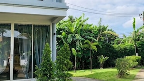 A modern building with a balcony, surrounded by lush greenery and a clear sky. - 217 Casa Del Mar Pool Villa@Casa Sakoo Phuket (Phuket)