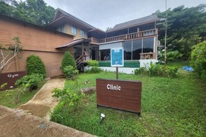 Ein Gebäude mit einem Schild, auf dem 'Clinic' und ein Schild mit 'Gym' zu sehen sind.