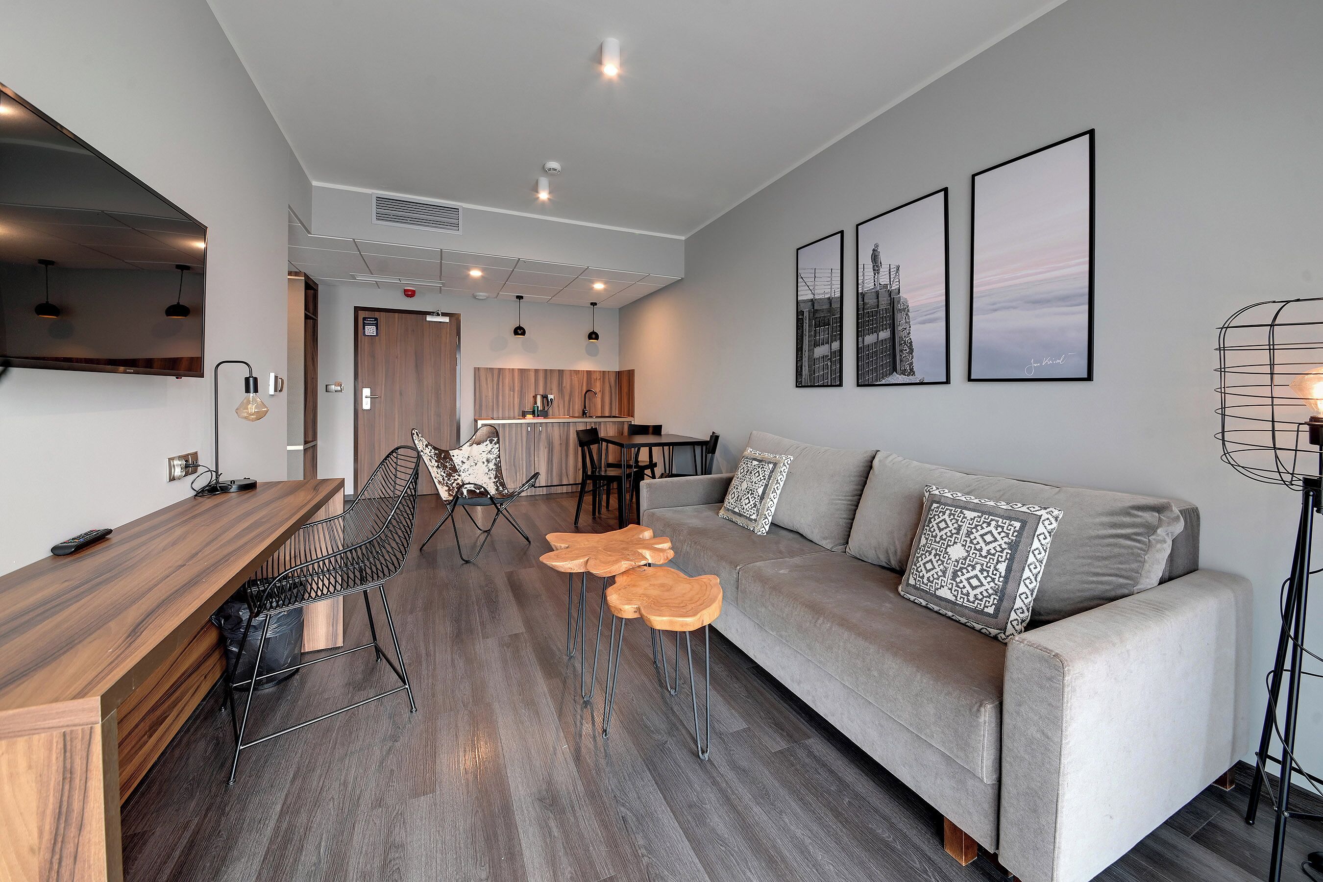 A modern living room with a sofa, coffee table, and dining area.