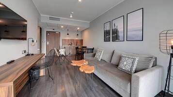 A modern living room with a sofa, coffee table, and dining area.