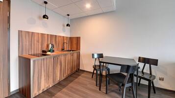 Eine moderne Küche mit Holzschränken, einer Spüle und einem Essbereich mit Tisch und Stühlen.