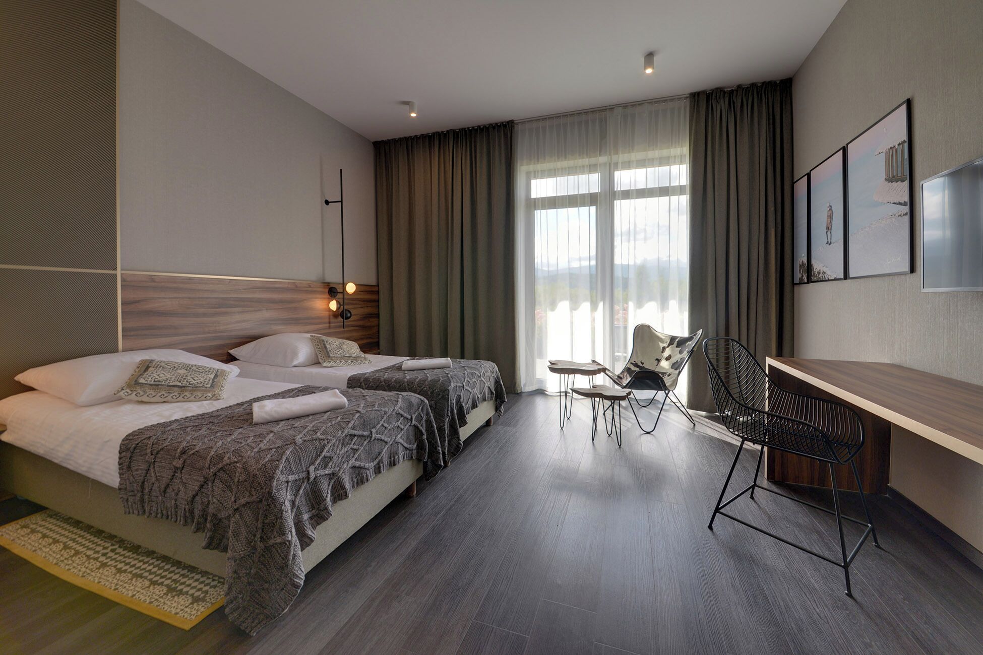 Une chambre d’hôtel moderne avec deux lits, un bureau et une chaise.