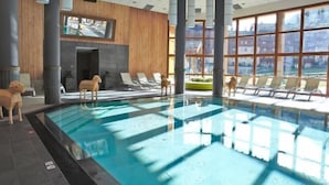 A modern indoor swimming pool with lounge chairs and a television screen on the wall. - Club Med Valmorel (Les Avanchers-Valmorel)