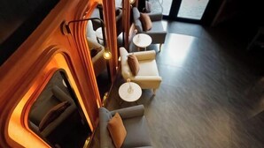 A modern lounge area with sofas and small tables, featuring warm lighting and a sleek design. - DAY & NIGHT by THE MOMENT (Chiang Mai)