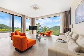 Ein modernes Wohnzimmer mit einer Couch, Sesseln und einem Couchtisch.