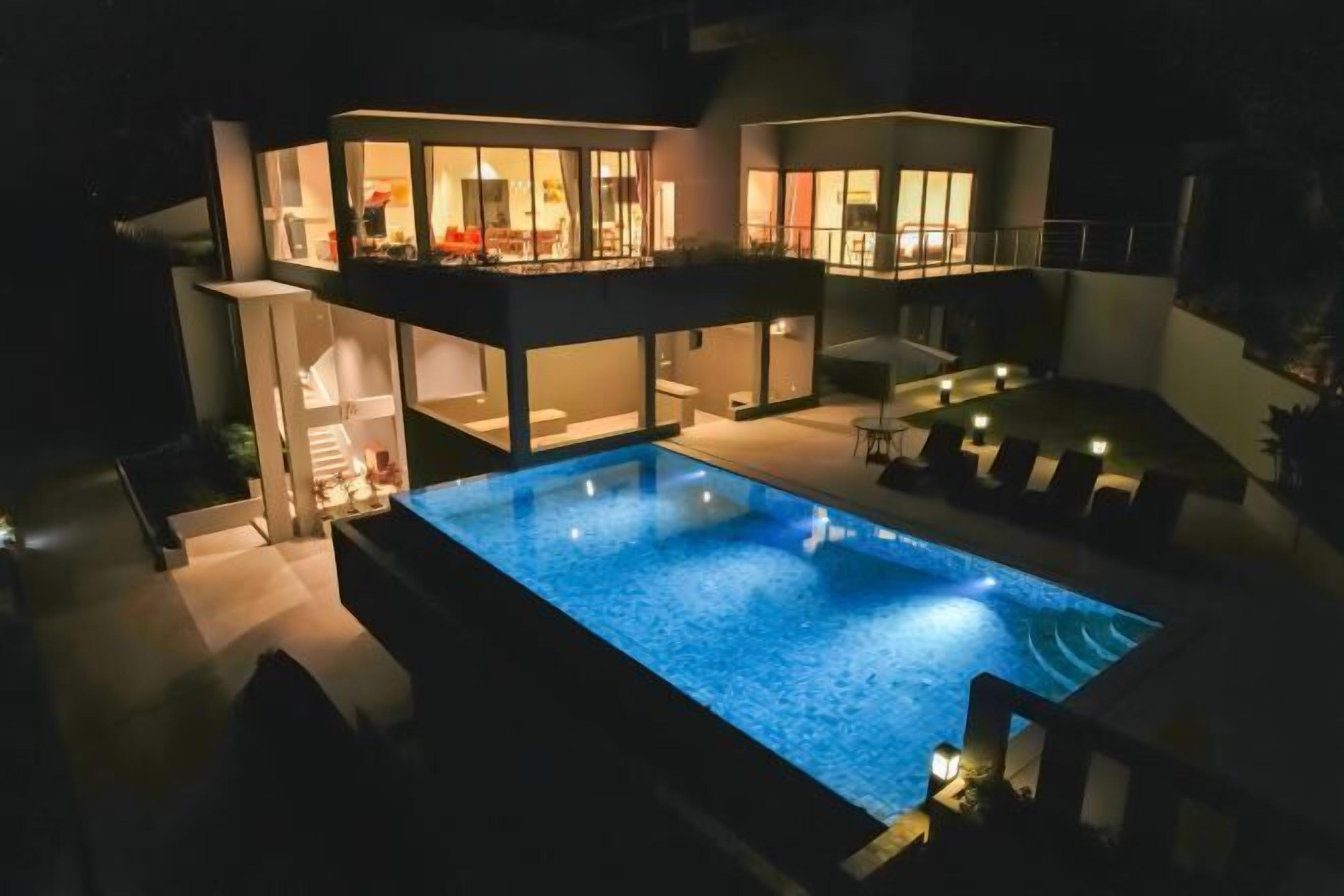 Une maison moderne à deux étages avec une piscine.