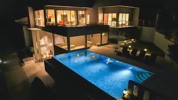 Een modern huis met twee verdiepingen en een zwembad.