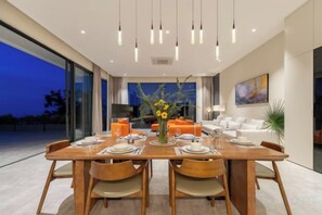 Un comedor moderno con una mesa de madera dispuesta para cuatro personas, rodeada de sillas.